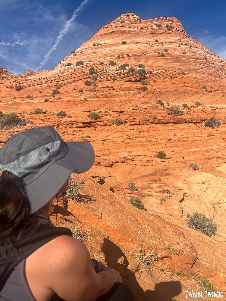 heather from trimm travels from the back gazing out over the orange sandstone formations while hiking to the wave in arizona