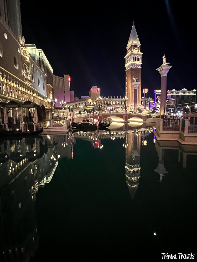 night shot of the venetian in las vegas with a water reflection and a bridge