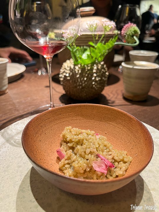 light brown bowl containing rice, rose petals and the rest of the previous lobster dish