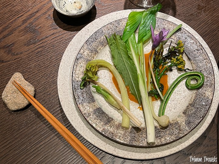 overhead of the seasonal green vegetables with orange lobster sauce and a set of chopsticks