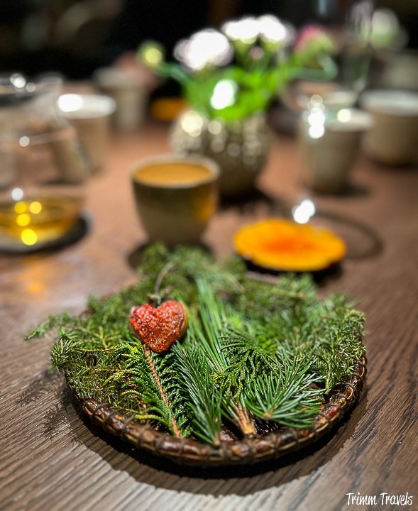 greens with a heart-shaped strawberry and a yellow custard on a brown table
