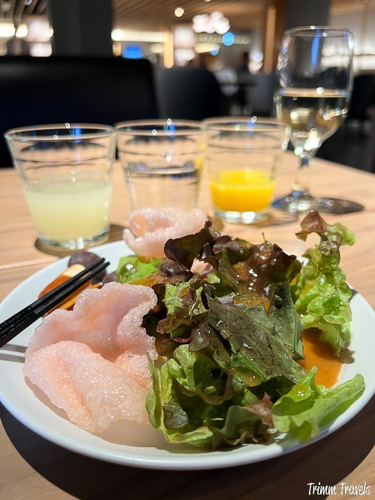 greens and three different kinds and colors of sake in the background