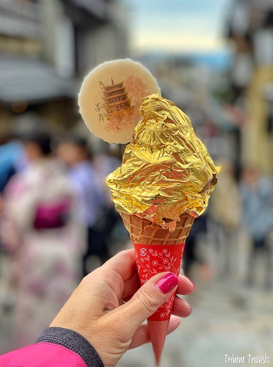 gold foiled wrapped ice cream in a cone with a white cookie stuck on the top left