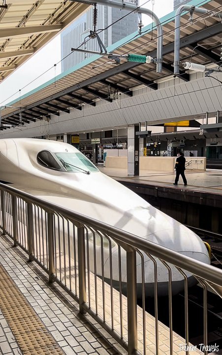 white nose of the futuristic bullet train arriving in a japan station
