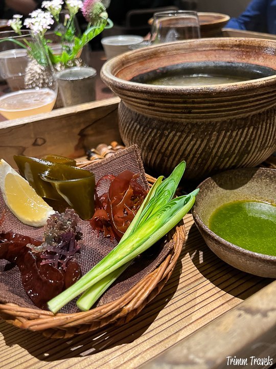 greens and lemon with a green sauce on a brown table